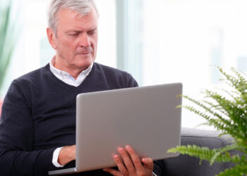 Bilgisayar kullanan yaşlı bir erkek